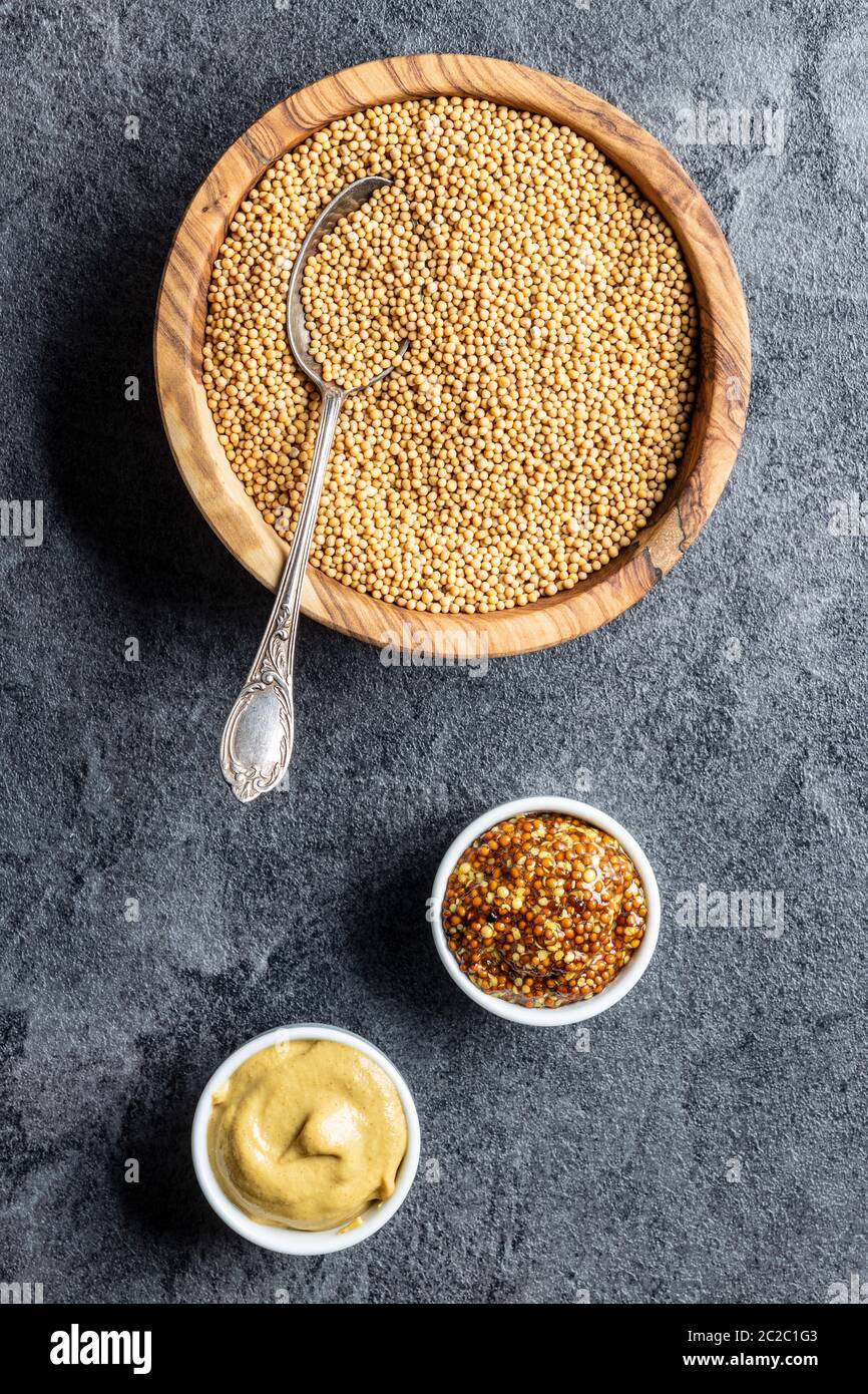 Yellow mustard and whole grain mustard and mustard seeds on kitchen