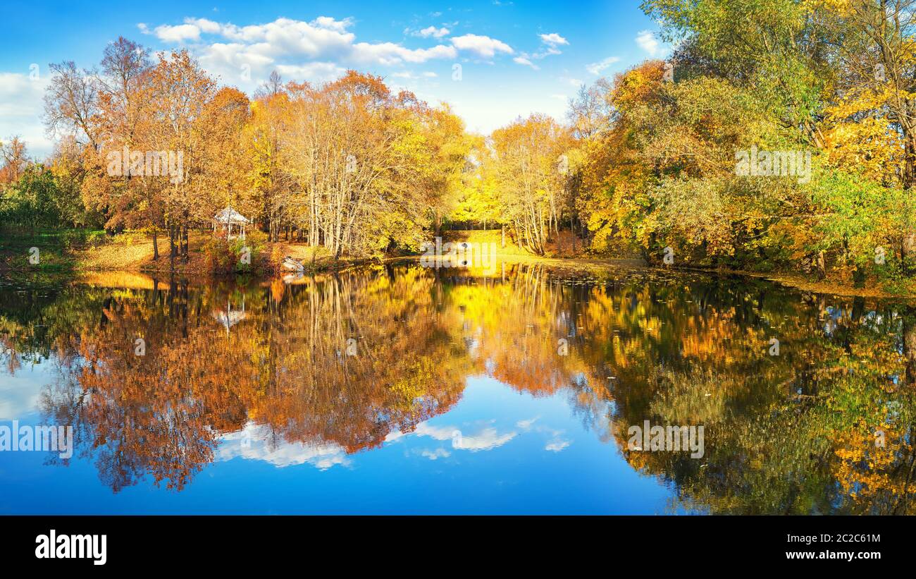 Sunny autumn landscape with blue sky over lake Stock Photo
