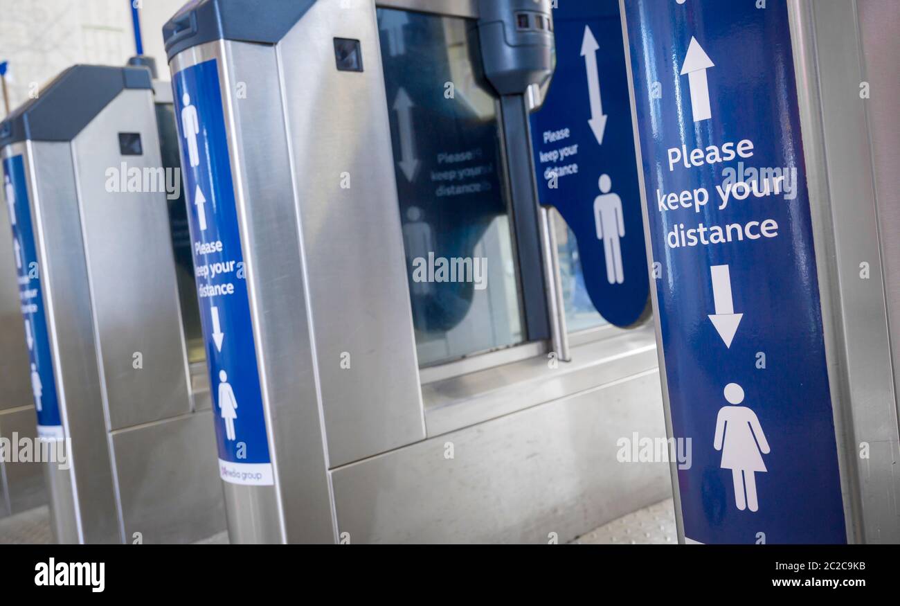 Markings on railway station ticket barriers asking people to respect the 2 metre social distancing rule due to the coronavirus pandemic in June 2020, Stock Photo