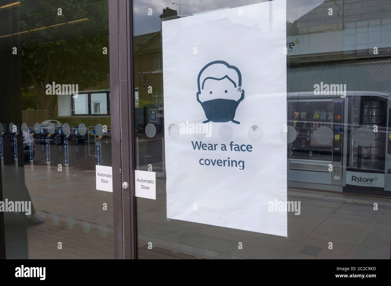 Poster at entrance to a railway station asking people to wear a face covering due to the coronavirus pandemic in June 2020, England, UK. Stock Photo