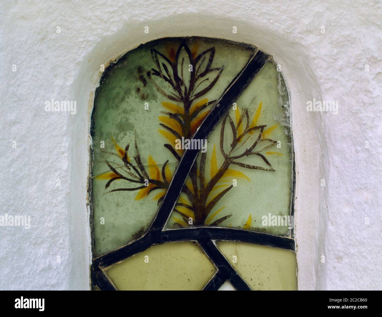 Exterior view of a fragment of painted glass in the form of a flower in upper part of E window of Llangar Old Parish Church, Denbighshire, Wales, UK. Stock Photo