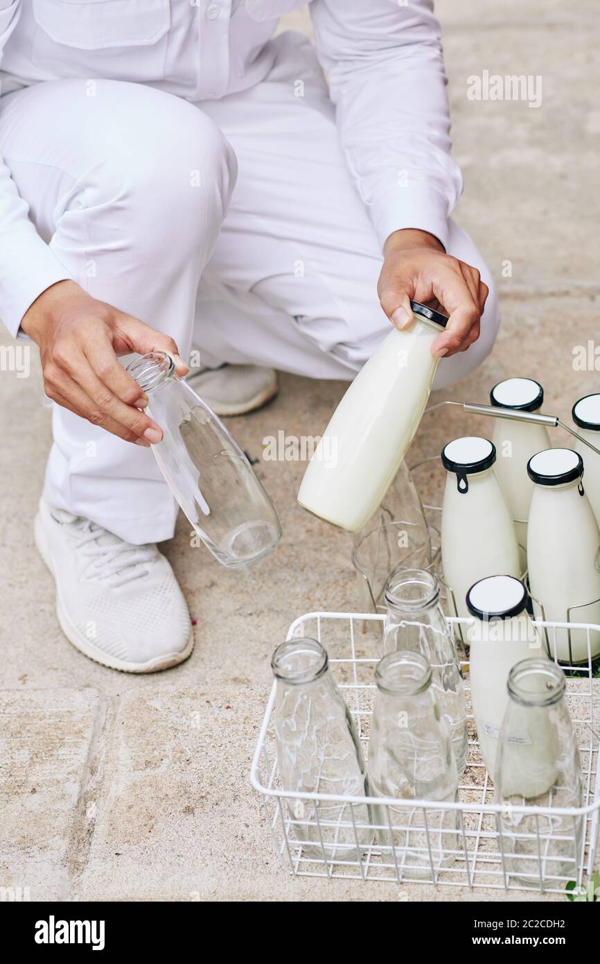 https://c8.alamy.com/comp/2C2CDH2/unrecognizable-modern-milkman-delivering-milk-and-bringing-back-empty-glass-bottles-vertical-high-angle-shot-2C2CDH2.jpg