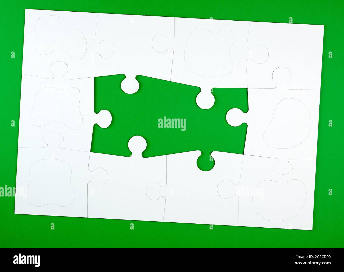 blank white big puzzles on green background, copy space Stock Photo