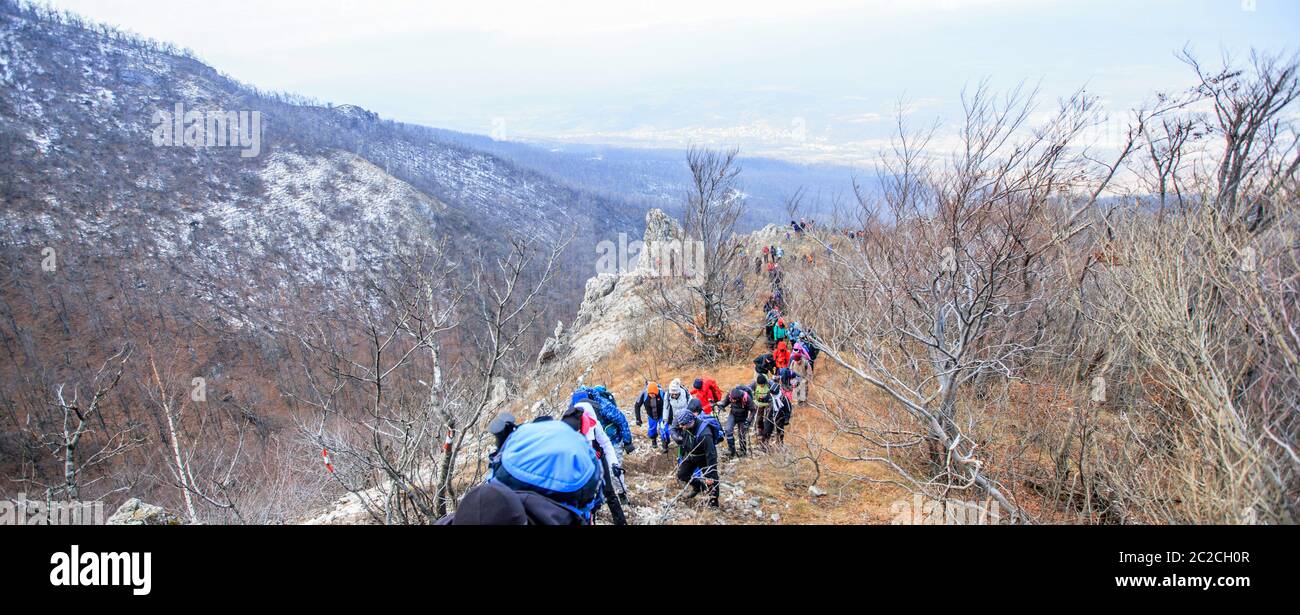 Group of Mountaineers Trekking Up Winter Mountain Landscape Stock Photo