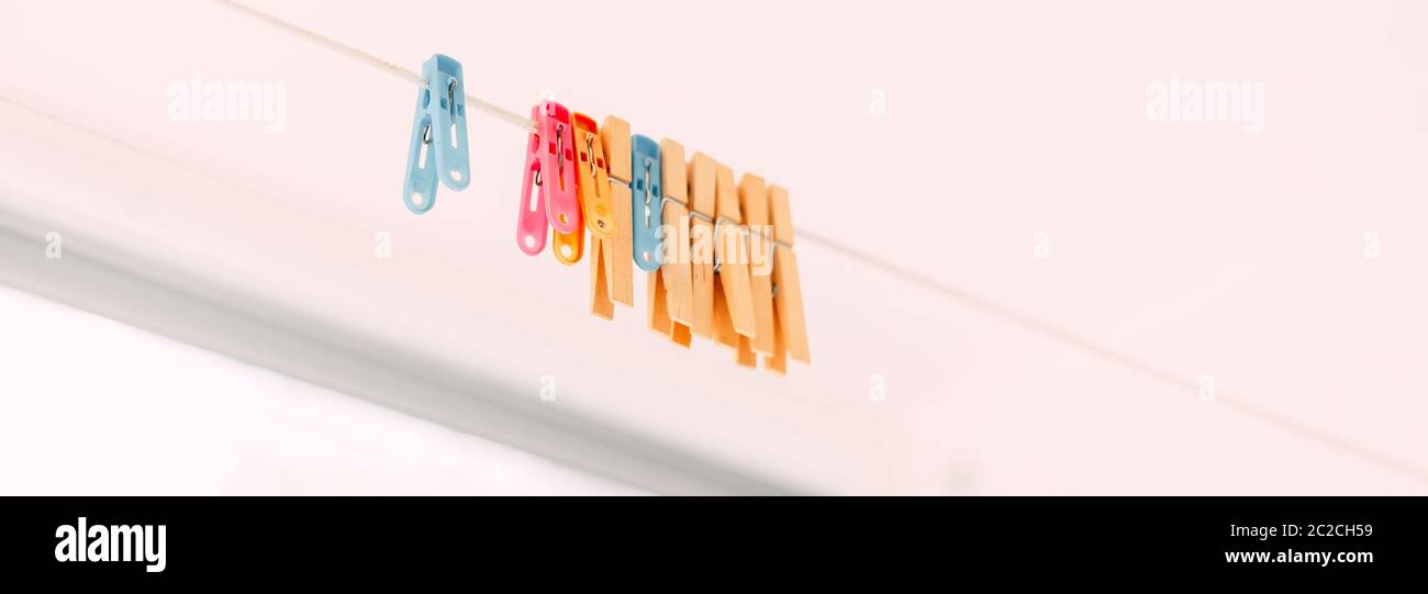 Colored clothespins on a rope on a blurred background Stock Photo