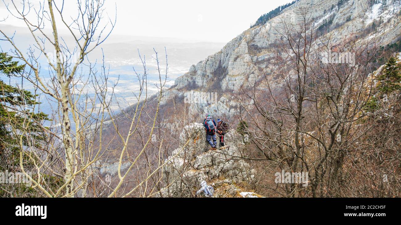 Hikers on the rocks on mountain enjoy the beautiful winter landscape Stock Photo