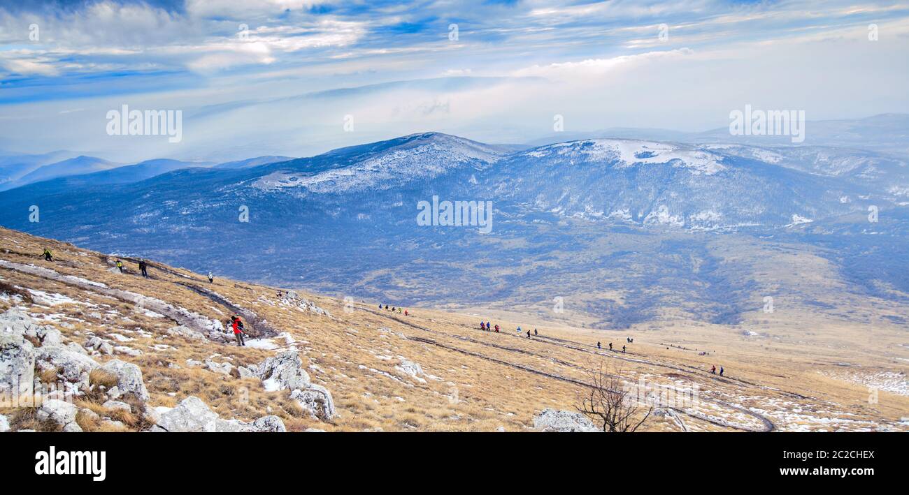 Amazing Winter Mountain Landscape. Group Of Mountaineers Descends Down Mountain Trail Stock Photo
