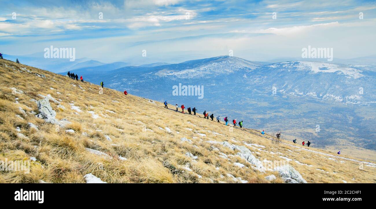 Amazing Winter Mountain Landscape. Group Of Mountaineers Descends Down Mountain Trail Stock Photo