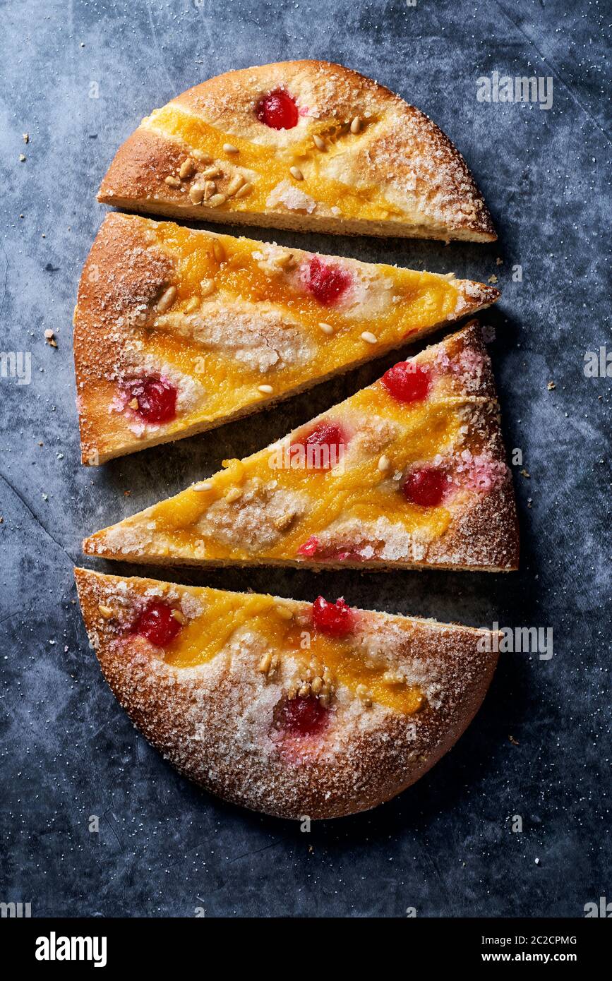 high angle view of some pieces of a coca de Sant Joan, a typical sweet flat cake from Catalonia, Spain, eaten on Saint Johns Eve, on a gray stone surf Stock Photo