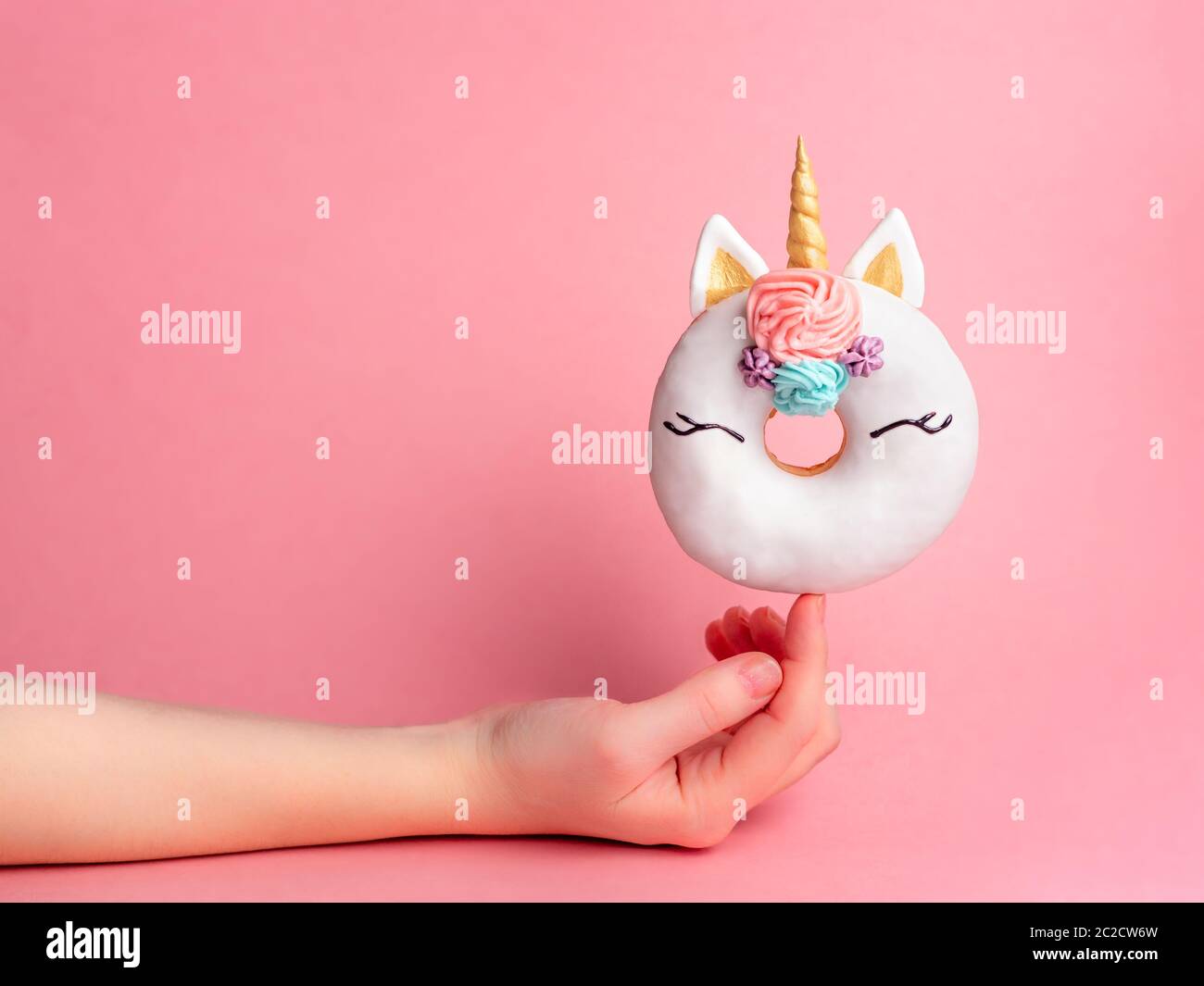 Unicorn donut on forefinger, copy space Stock Photo