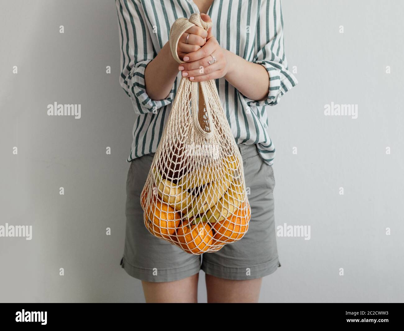 woman standing with mesh bag in hands Stock Photo