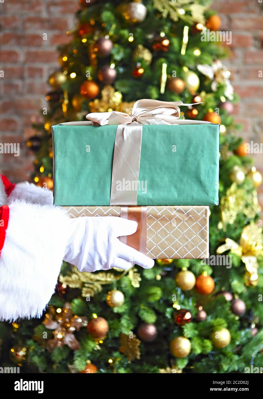 Santa Claus secretly putting gift boxes by the Christmas tree Stock ...