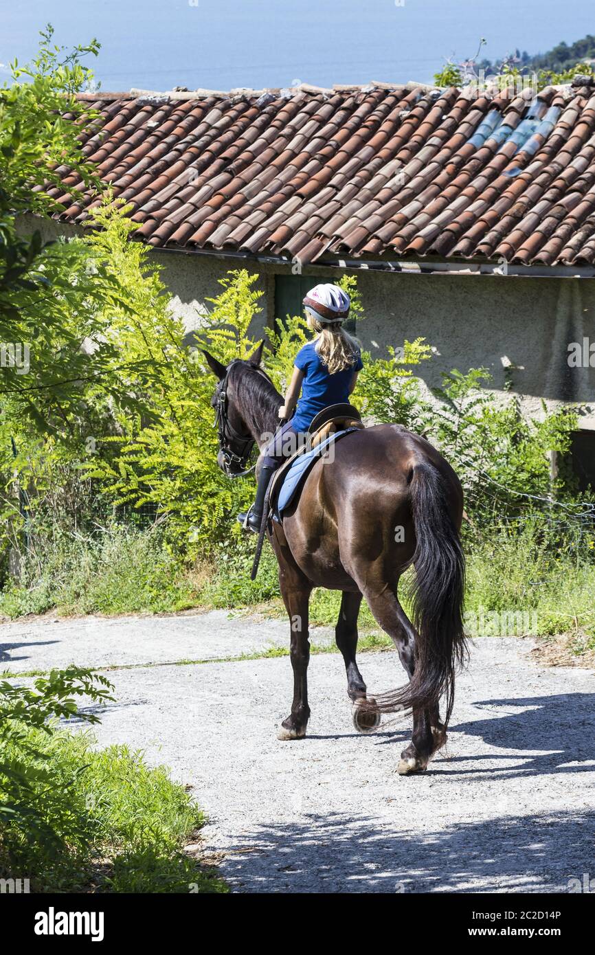 Girl (9) on horse, Lake Garda, Toscolano-Maderno, Italy Stock Photo