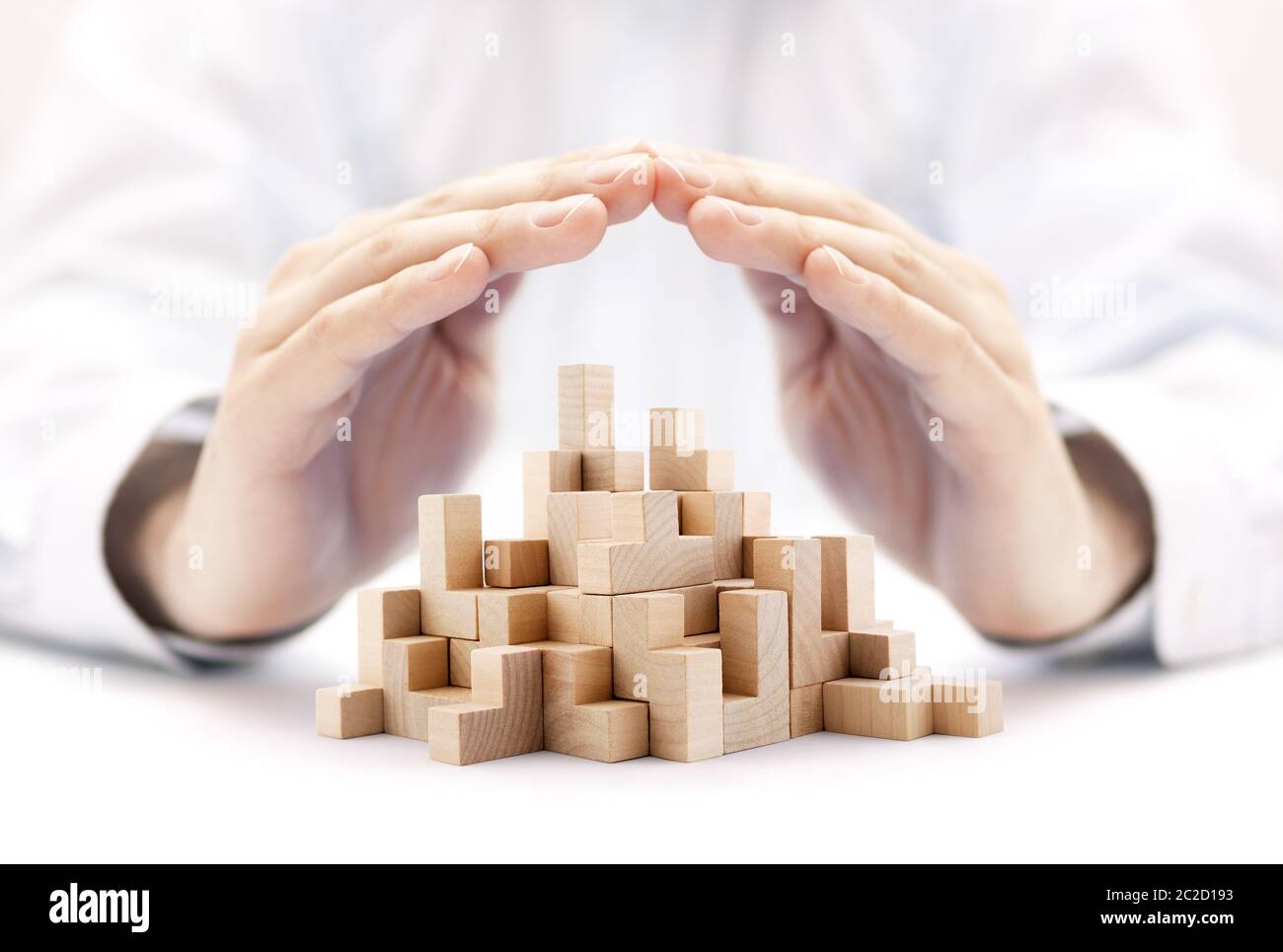 Safety business development concept. Wooden blocks covered by hands. Stock Photo