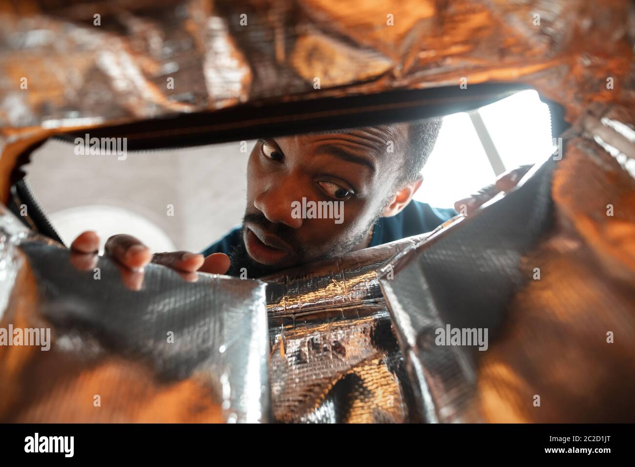 In old postal, delivery box. African-american man looking for job in unusual places at his home. Crazy, funny way to find career and going up. Concept of crisis, unemployment, finance, business. Stock Photo