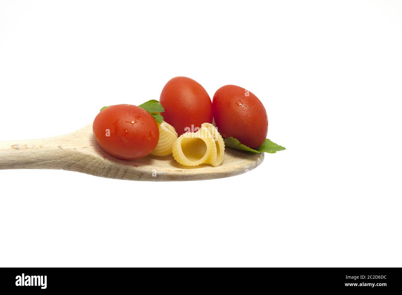 wooden spoon with pasta topped with cherry tomatoes Stock Photo