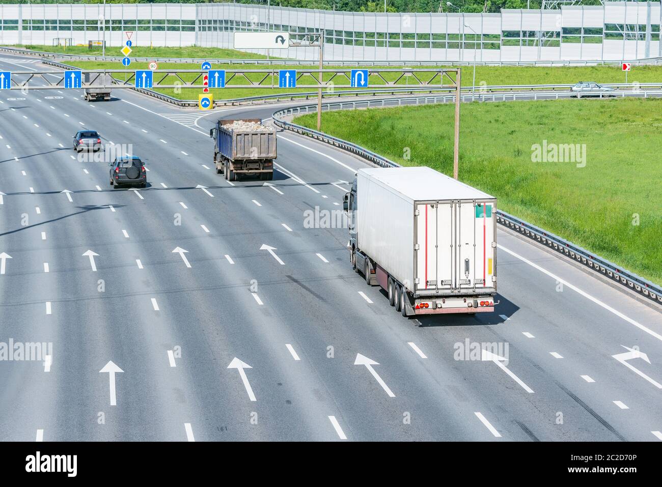 Freight trucks and passenger cars move on the modern highway Stock ...