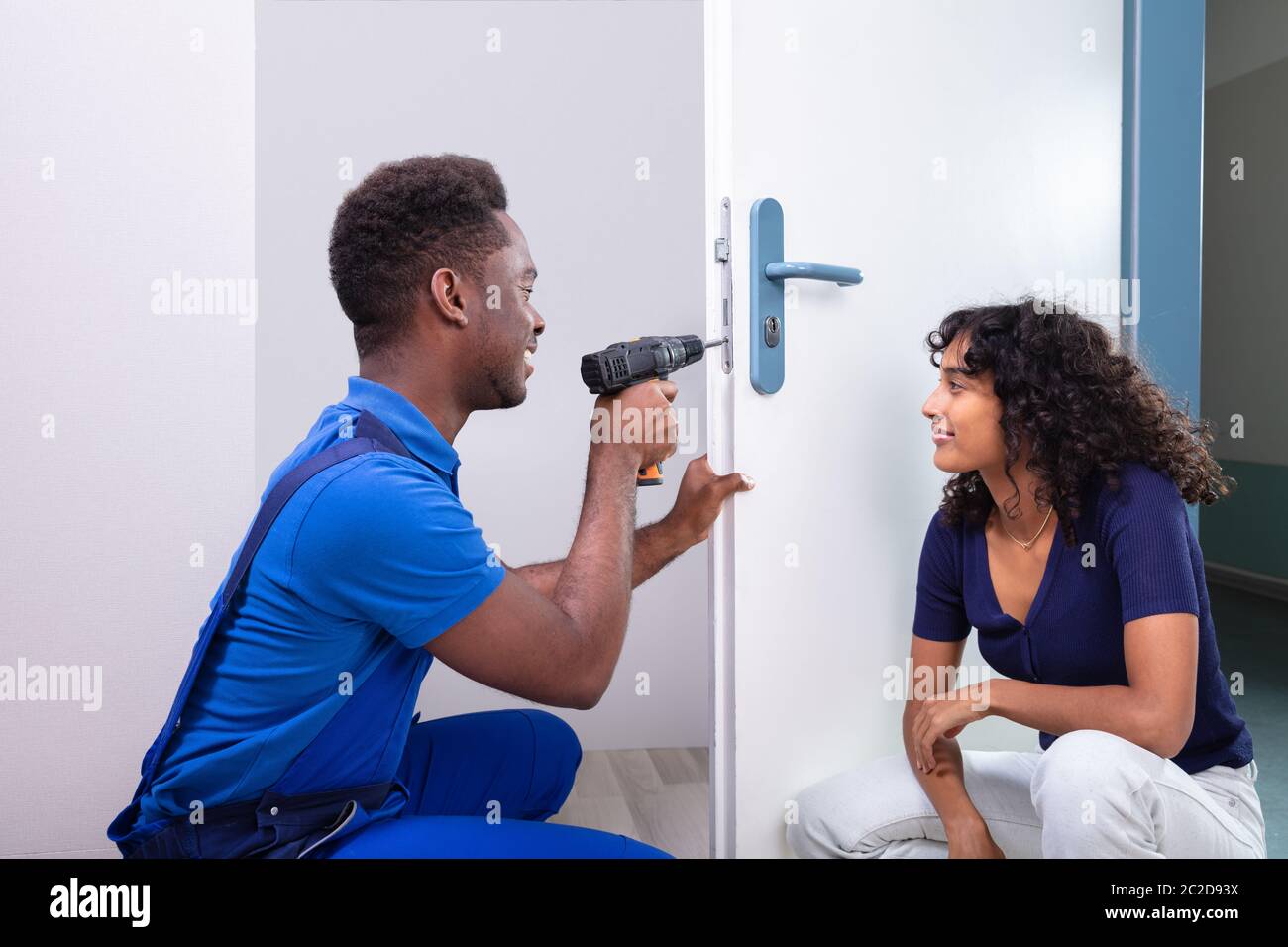 Technician Fixing The Door Lock At Clients Home Stock Photo