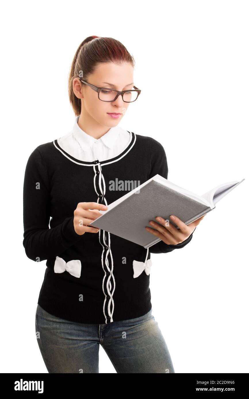 Reviewing notes. Reading something. Beautiful young student girl with glasses looking at an open notebook, isolated on white background. Stock Photo