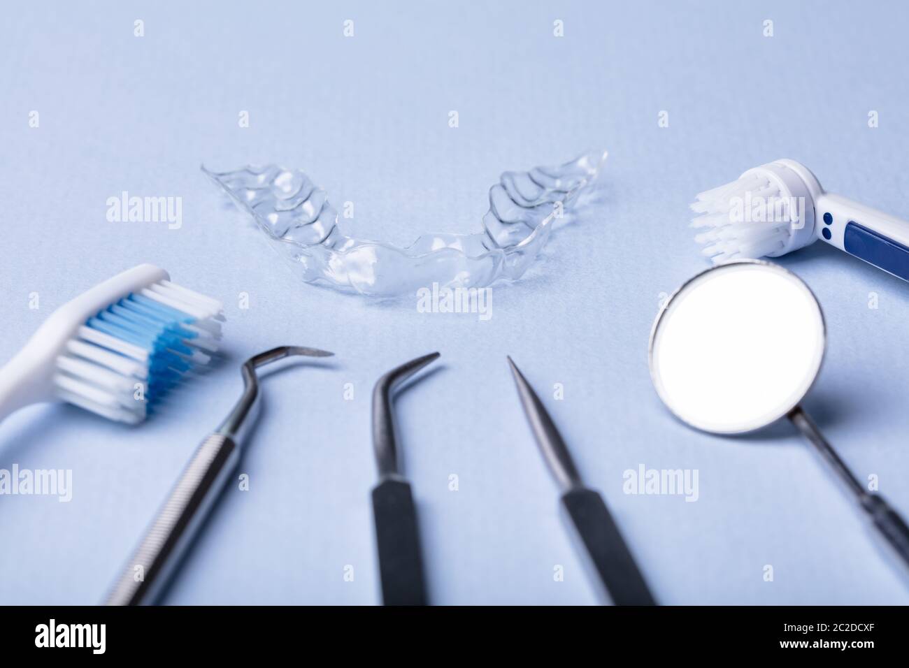 Dental Instruments And Clear Aligner On Color Background Stock Photo