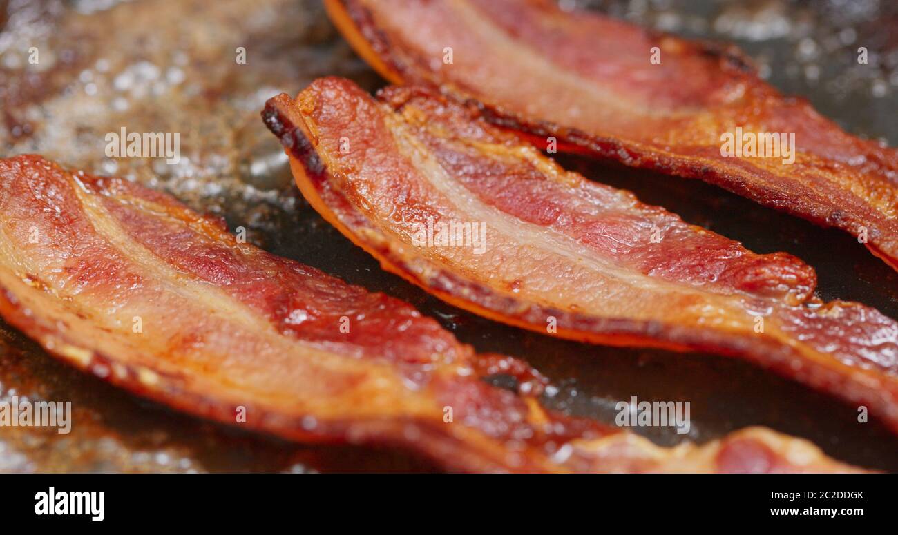 Fry bacon in pan in kitchen Stock Photo Alamy