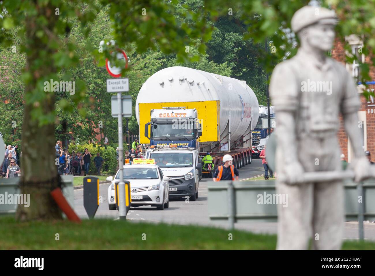 Rugeley, Staffordshire, UK. A 140ft medical oxygen tank makes its five-day journey along the roads of Staffordshire and the midlands. This is a major operation involving police, tree cutters, and BT engineers to make sure it fits under overhead cables. The container is 40m long, 6.5m wide and is carried on multiple vehicles with a total of 128 wheels. The load started its journey from Cheshire on Monday and will reach its destination in Warks on Friday. Credit: Peter Lopeman/Alamy Live News Stock Photo