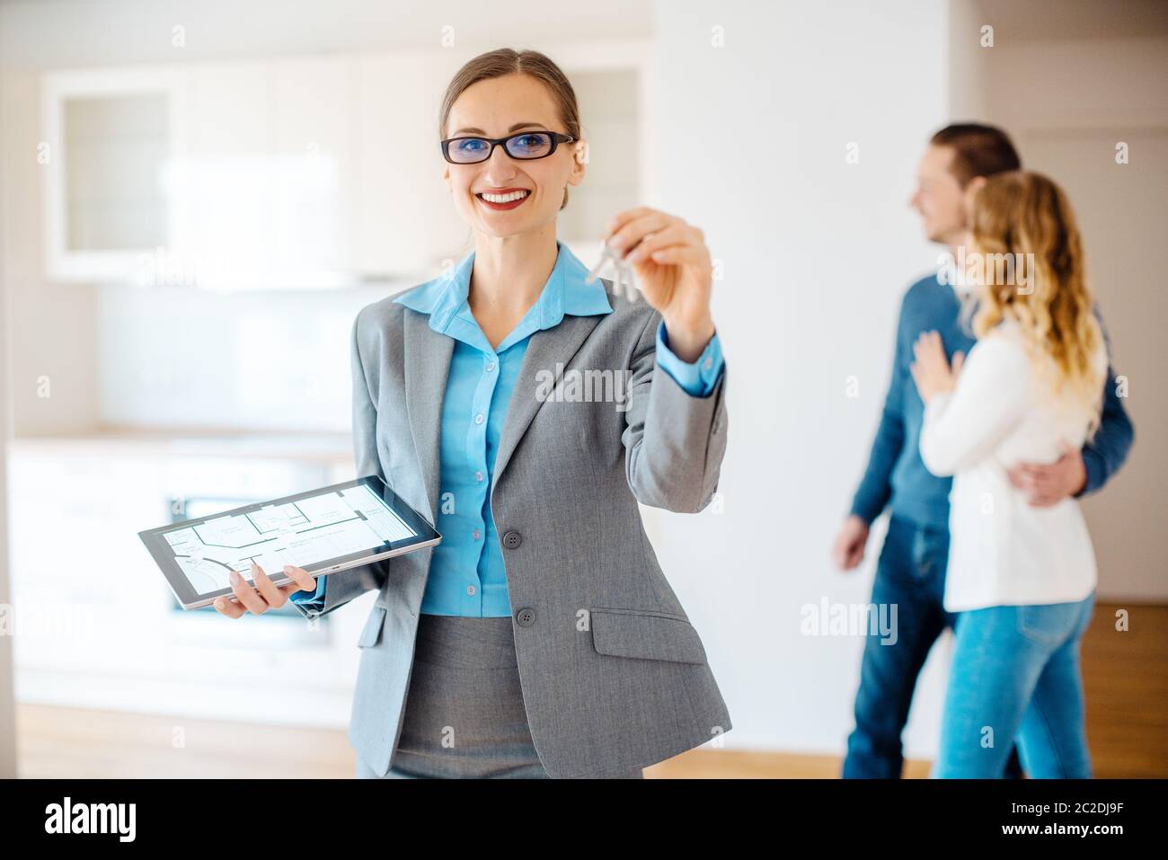 Apartment broker with keys to and floorplan of the new house, clients