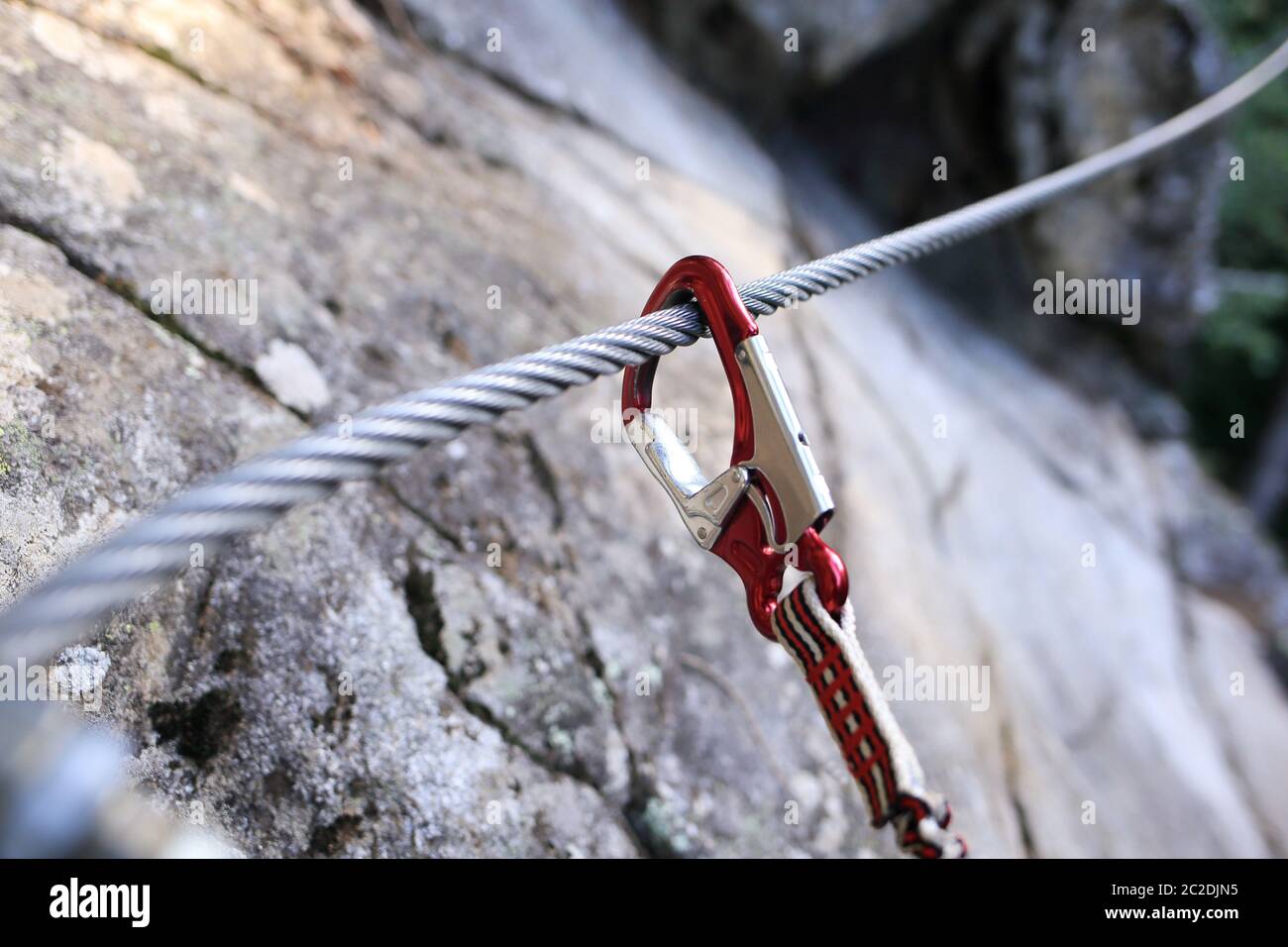 safety hook on a cable in a rock wall Stock Photo - Alamy