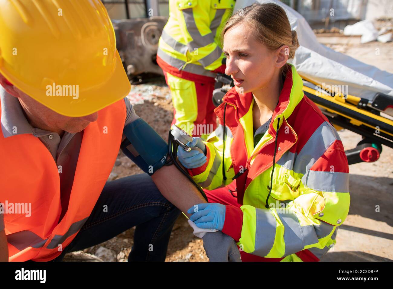 Paramedic Measuring Blood Pressure And Talking To Man After Accident On paramedic-measuring-blood-pressure-and-talking-to-man-after-accident-on