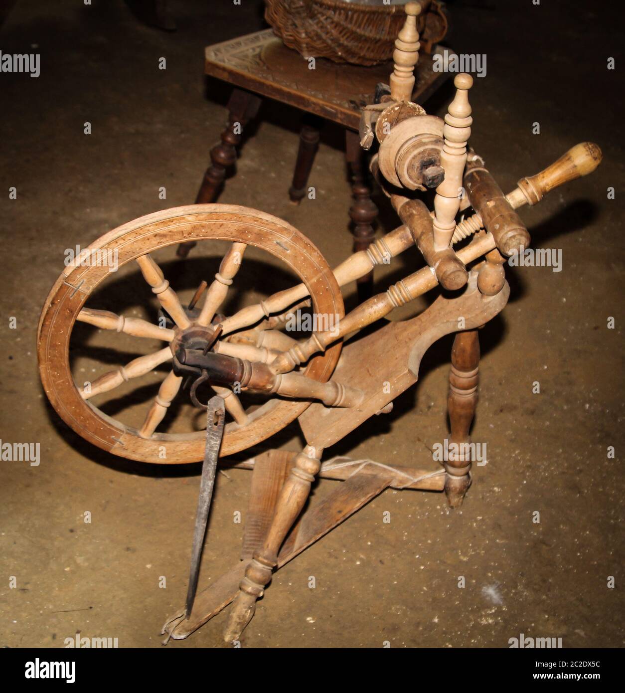 An old wooden spinning wheel was spun on the wool Stock Photo
