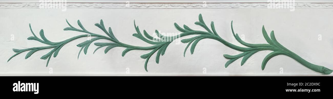 Relief of a green plant on a white wall Stock Photo