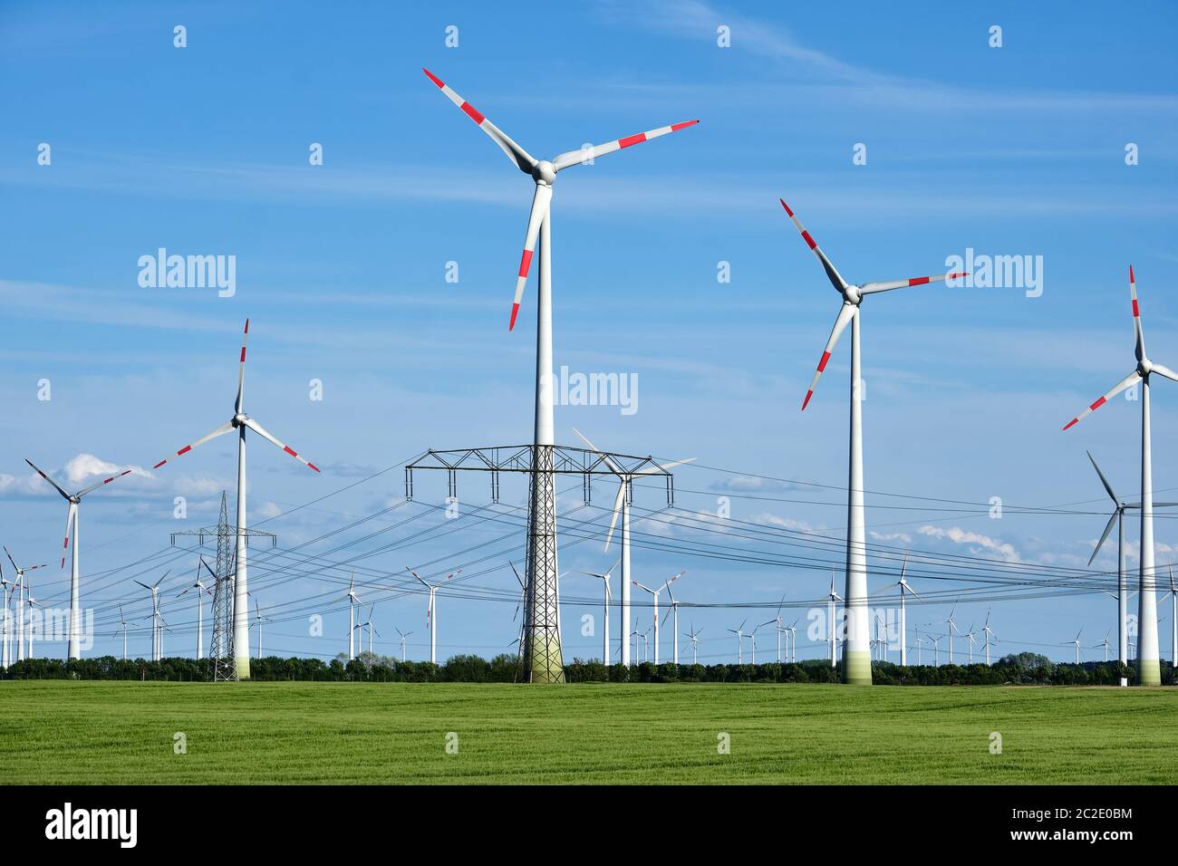 Overhead power lines and wind engines seen in Germany Stock Photo
