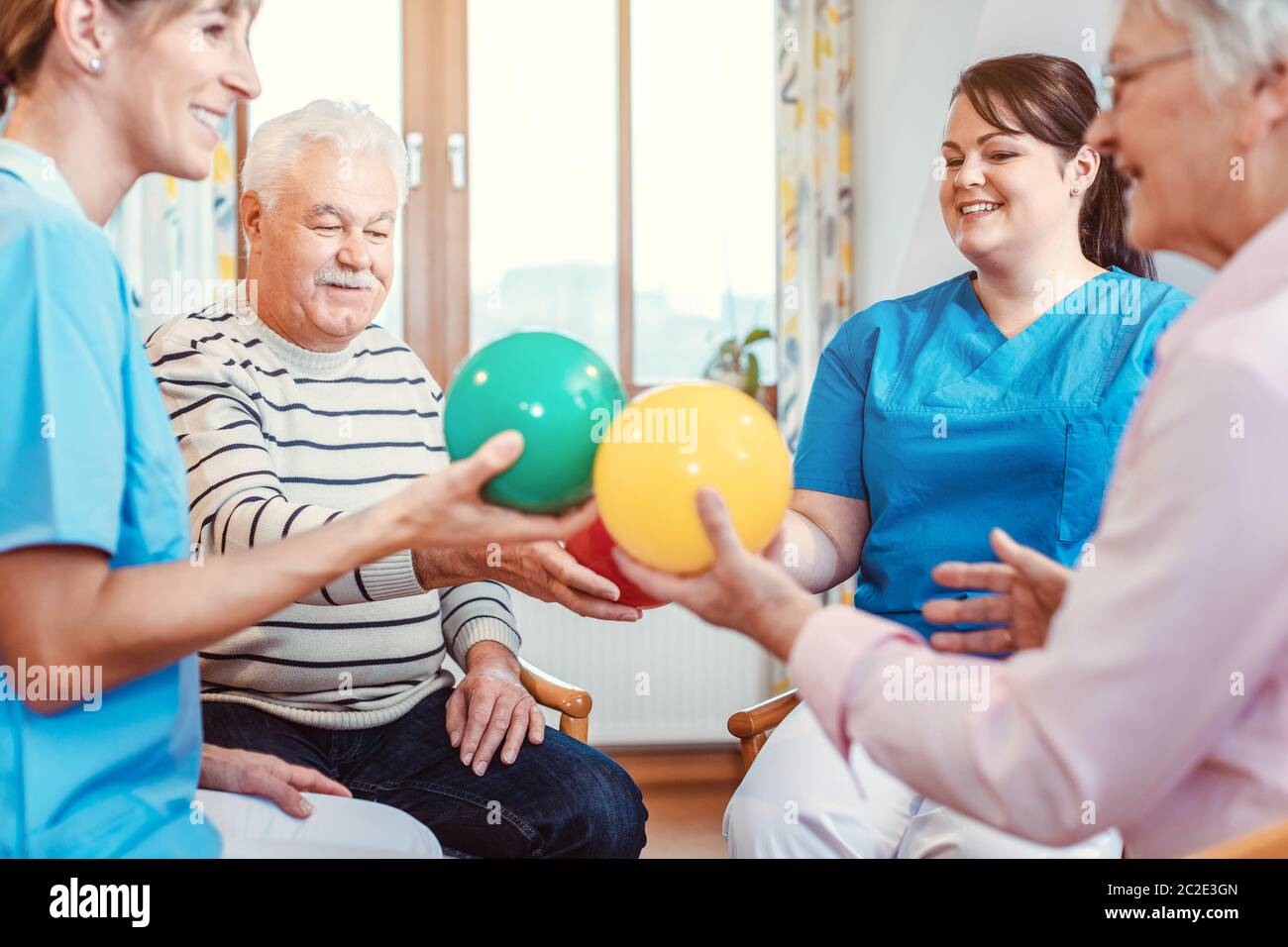 Group of seniors doing sport and gymnastics with balls in the pensioners home Stock Photo