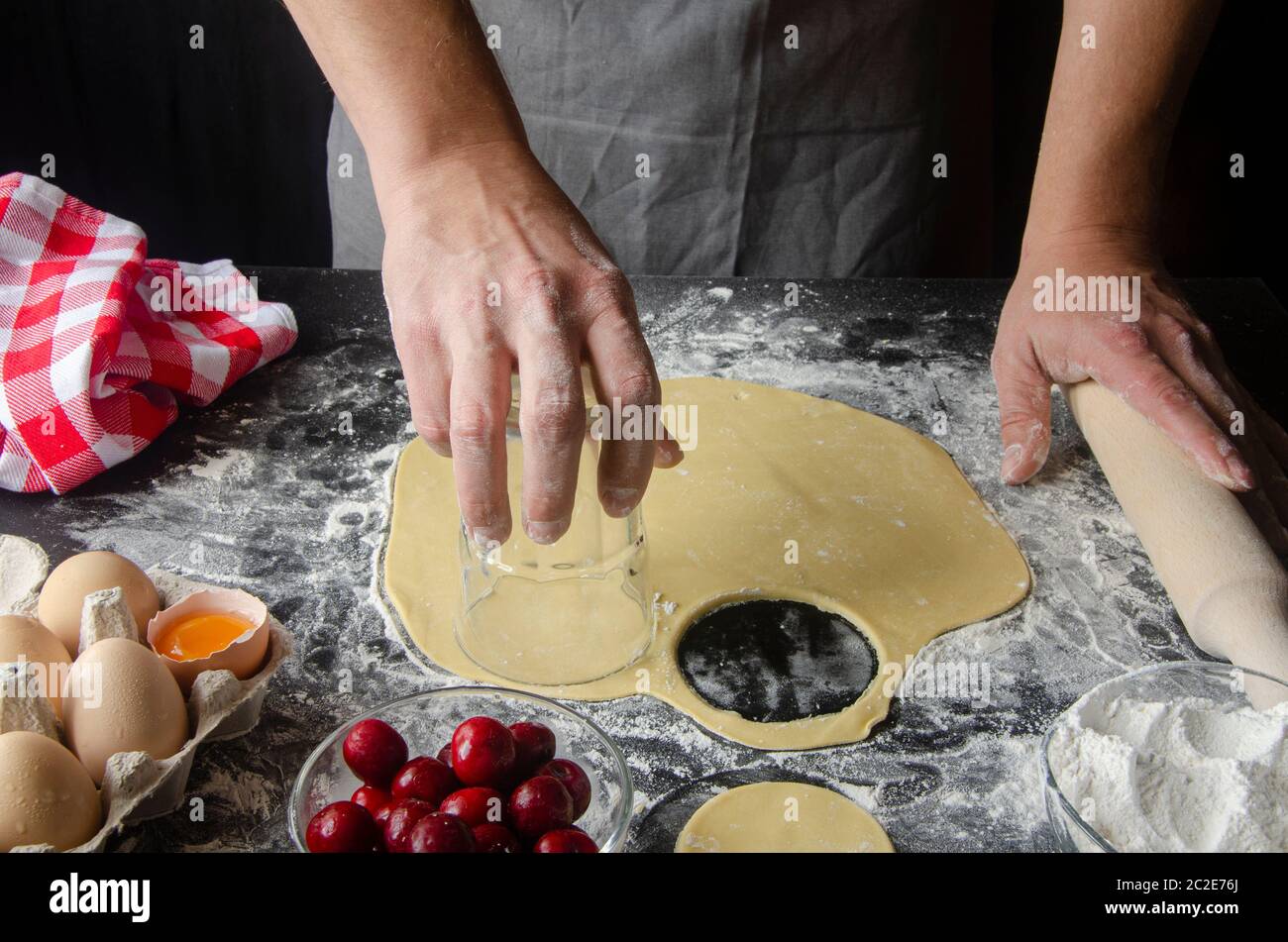 Men's hands prepare dough for pizza on a black table Stock Photo - Alamy