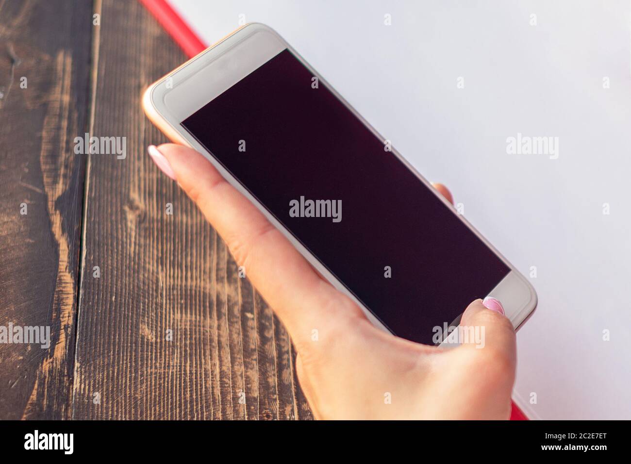 Download Mockup Image Of A Woman S Hands Holding White Mobile Phone With Blank Black Screen On Background Of White Sheet Of Paper At A Cafe Stock Photo Alamy Yellowimages Mockups