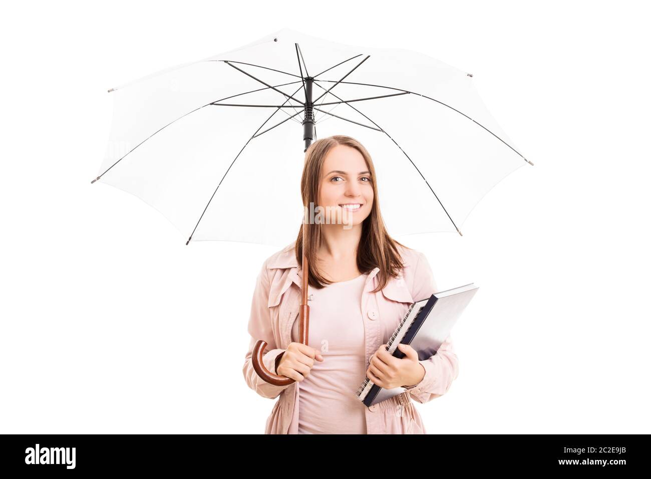Young girl under an umbrella holding some books, isolated on white background. Stock Photo