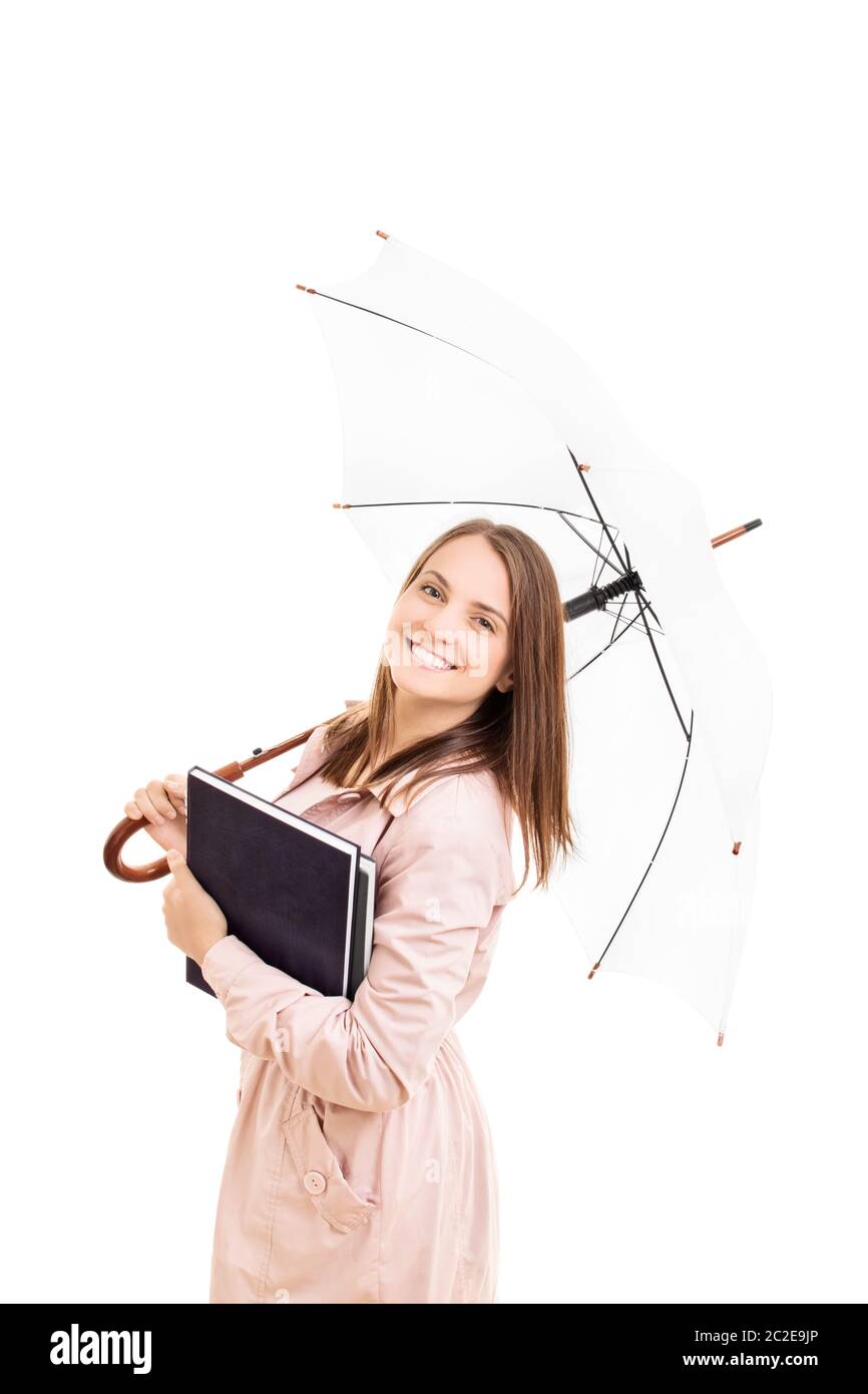 Young girl under an umbrella holding some books, isolated on white background. Stock Photo