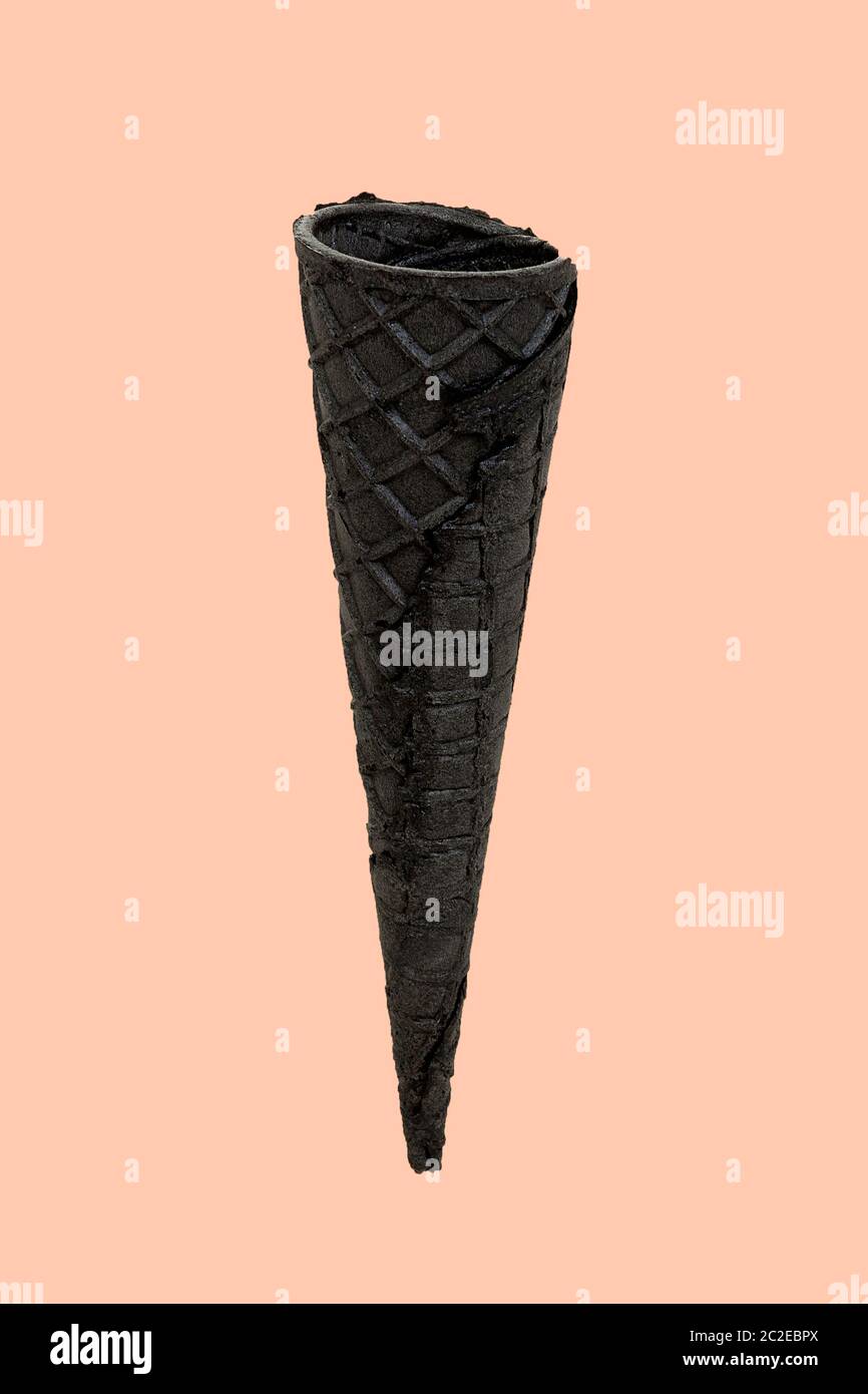 Empty black wafer cone on a beige background with a copy space. Layout ...