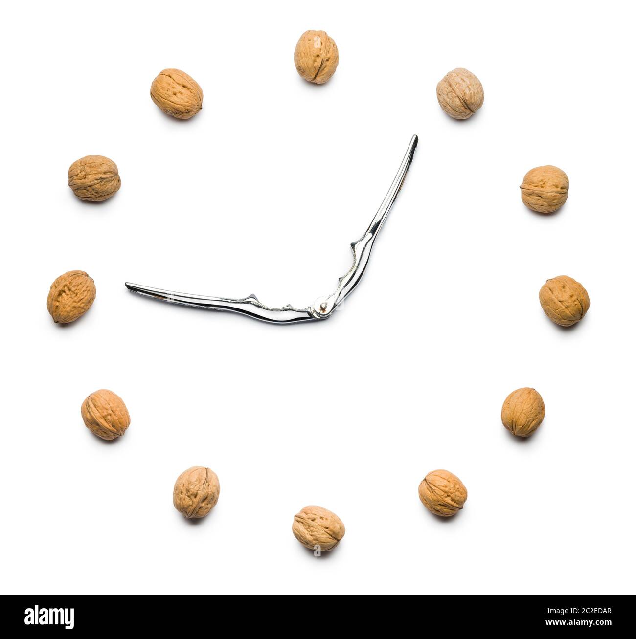 walnuts clock with nutcracker as hands on white background Stock Photo