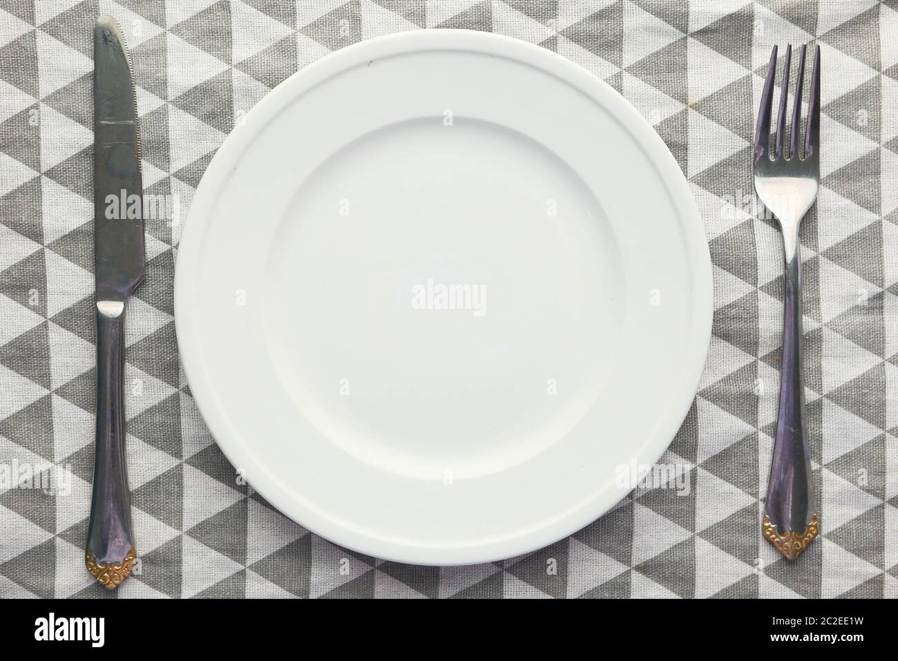 Clean empty white plate with knife and fork. Stock Photo