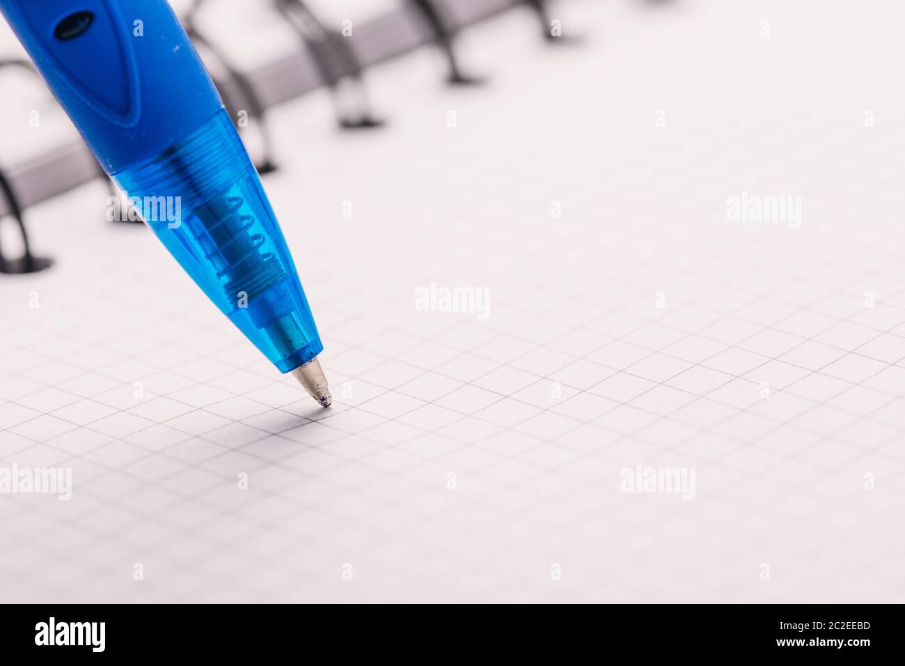 Opened notepad in a cage with an automatic plastic ballpoint pen close-up. Stock Photo