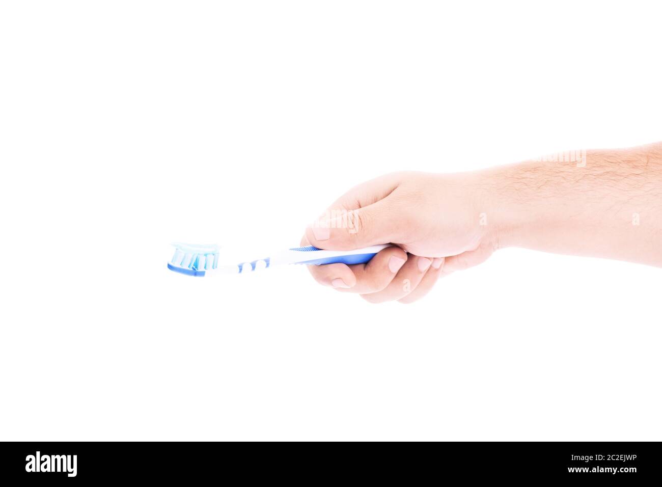Close-up shot of a male hand holding a toothbrush with paste on it ...