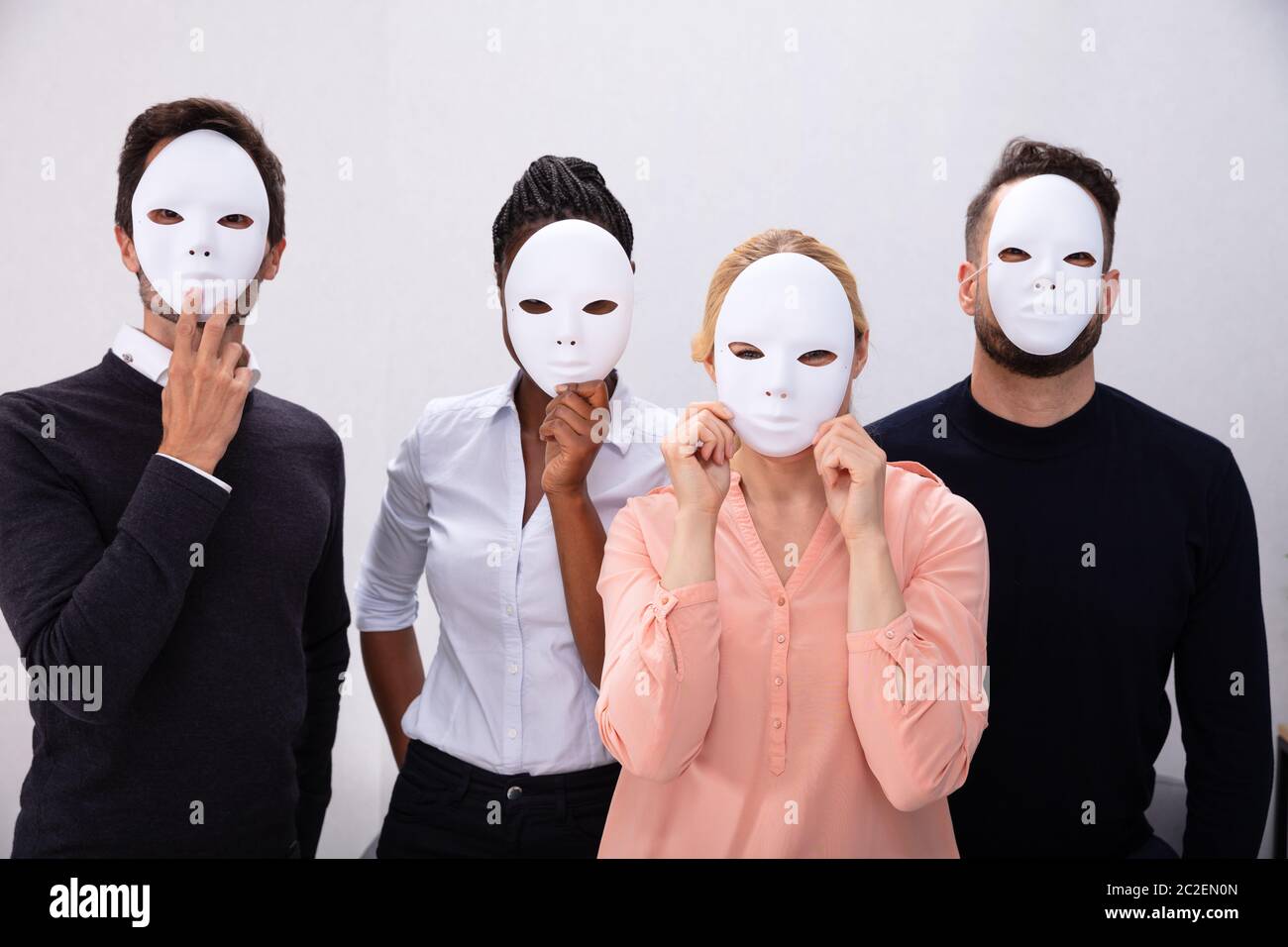 Group Of People Standing Together Covering His Face With White Masks Stock Photo