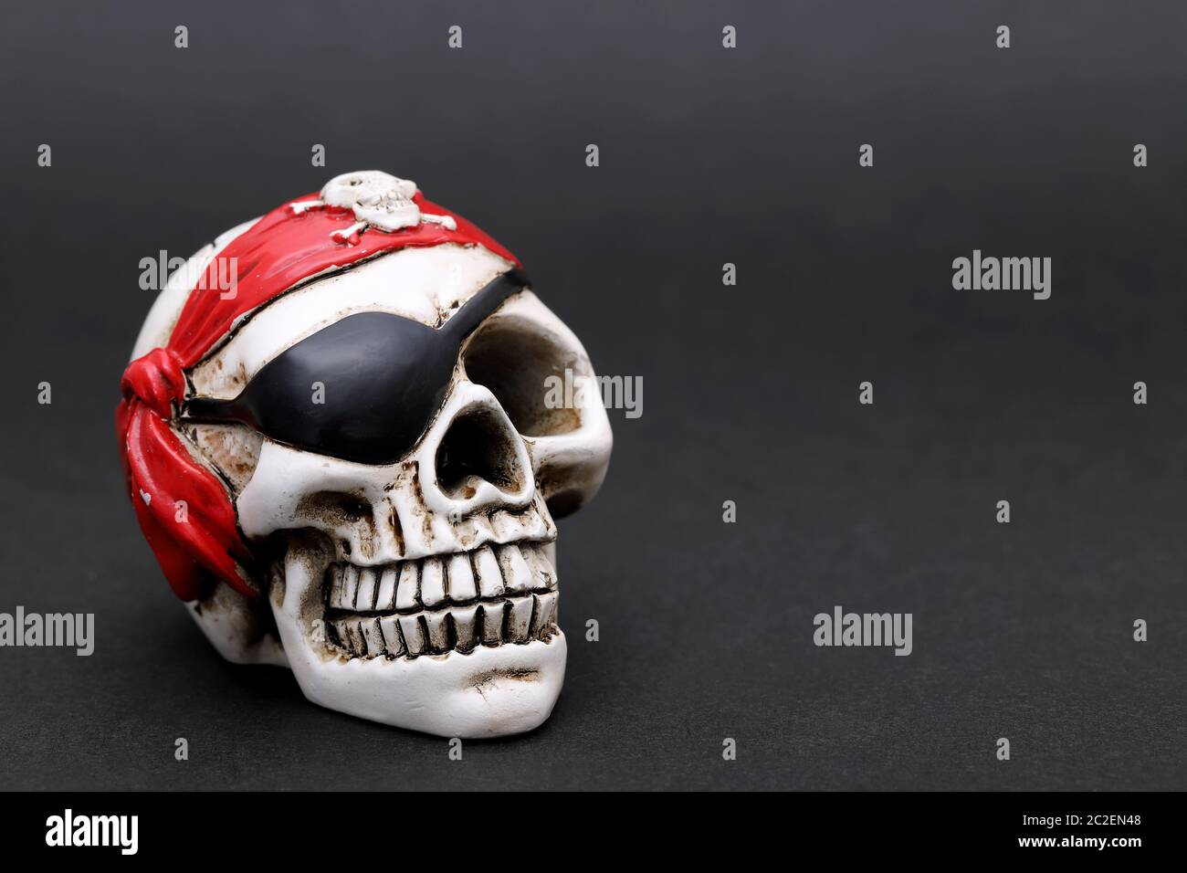 Pirate skull with red head kerchief on dark background Stock Photo