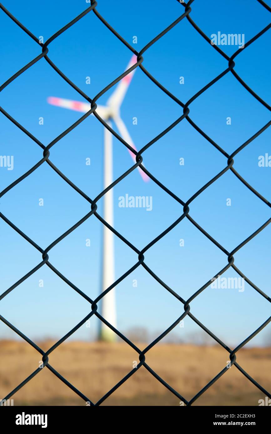 Wind turbine behind a fence in an industrial area in Magdeburg Stock Photo