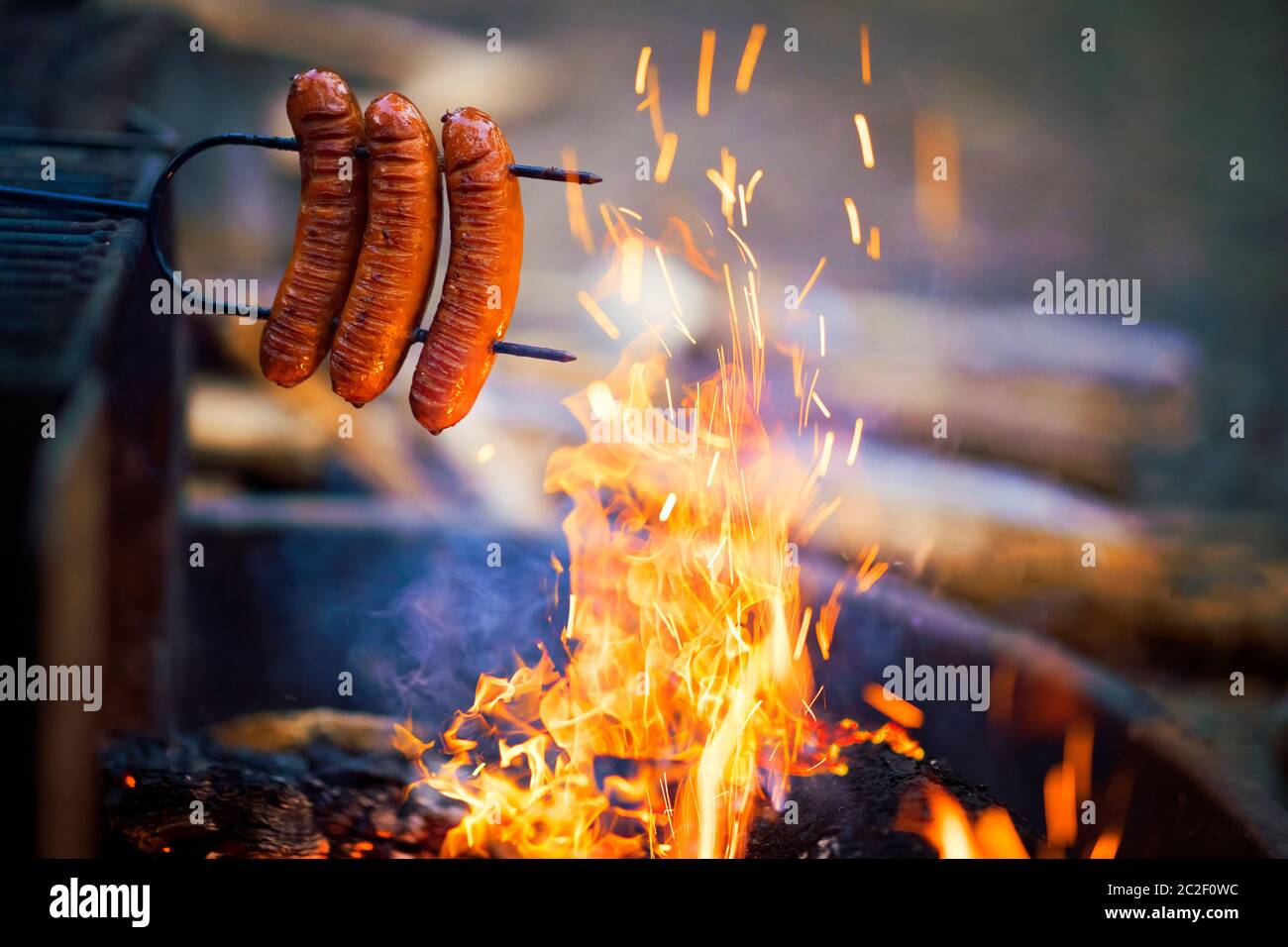 Preparing sausage on campfire, camping dinner Stock Photo