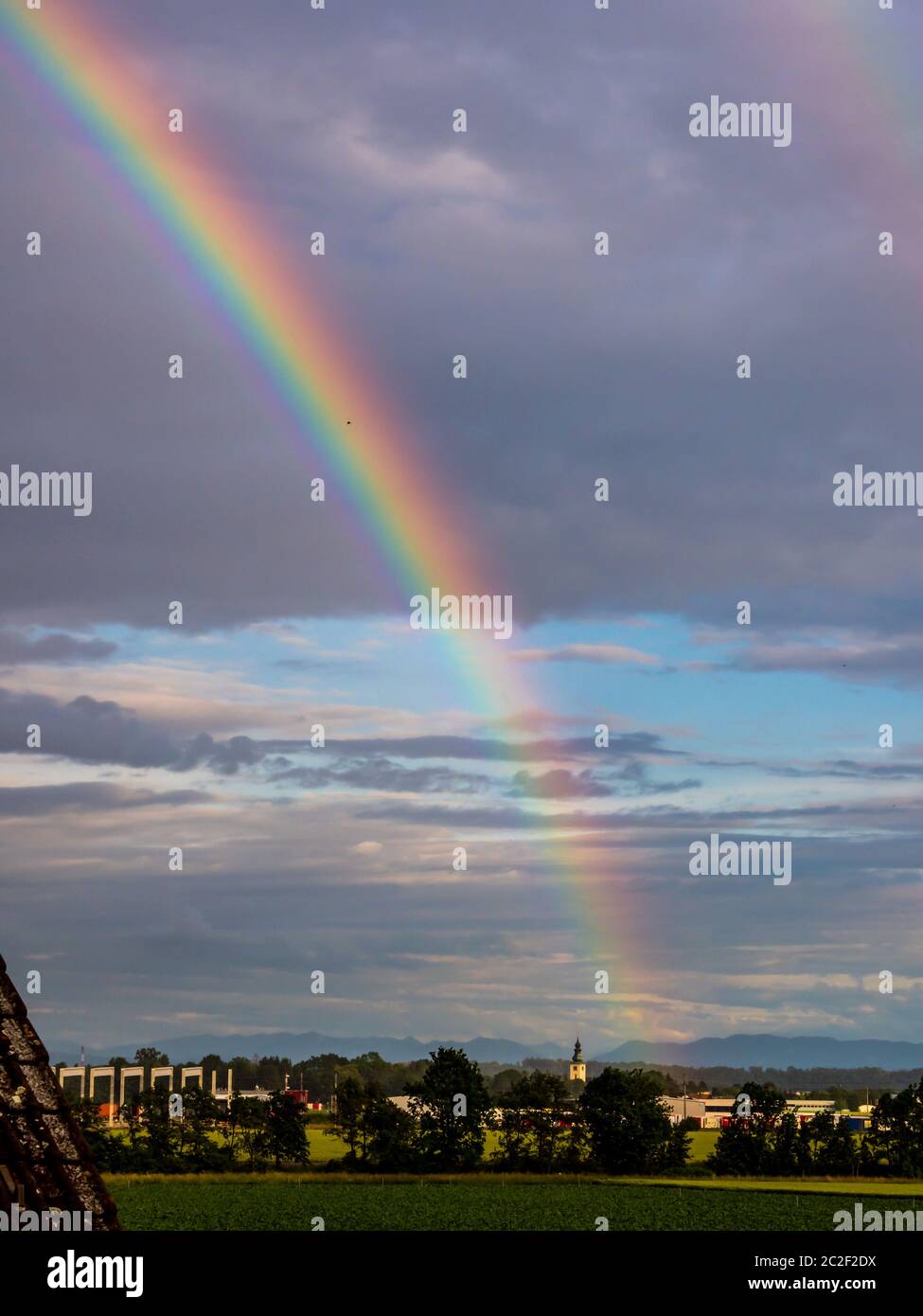 a rainbow is emerging after a thunderstorm rain in the sky Stock Photo