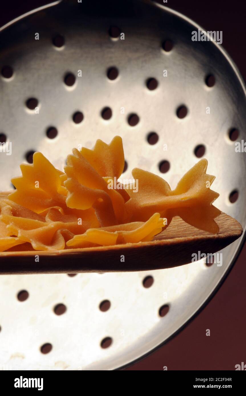 Uncooked farfalle pasta on the spoon Stock Photo