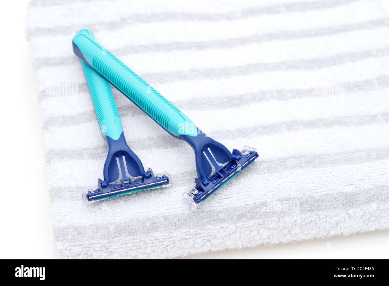 blue disposable shaving razor with towel on white background Stock Photo