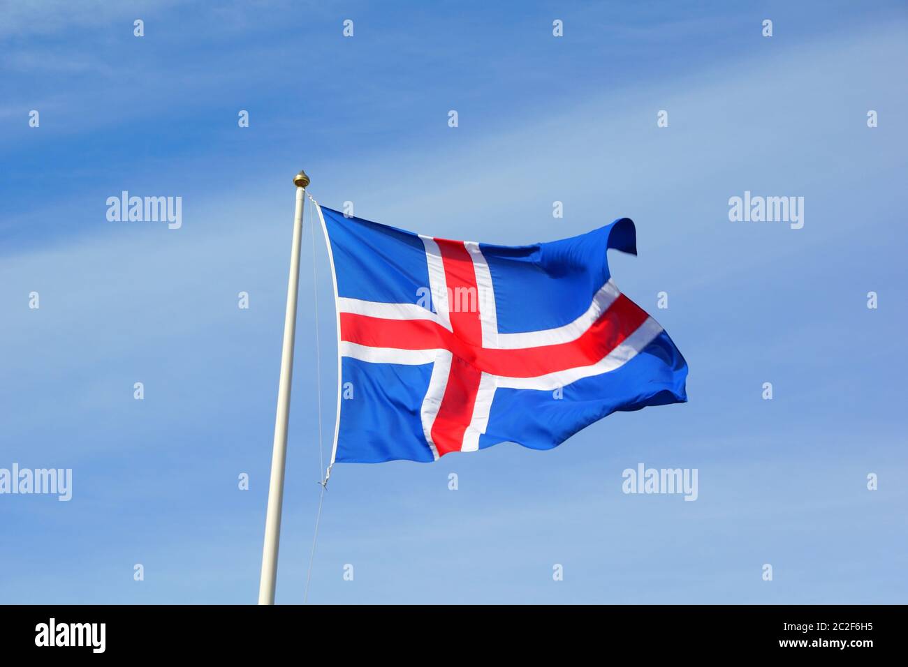 Proudly flying flag against a blue sky Stock Photo